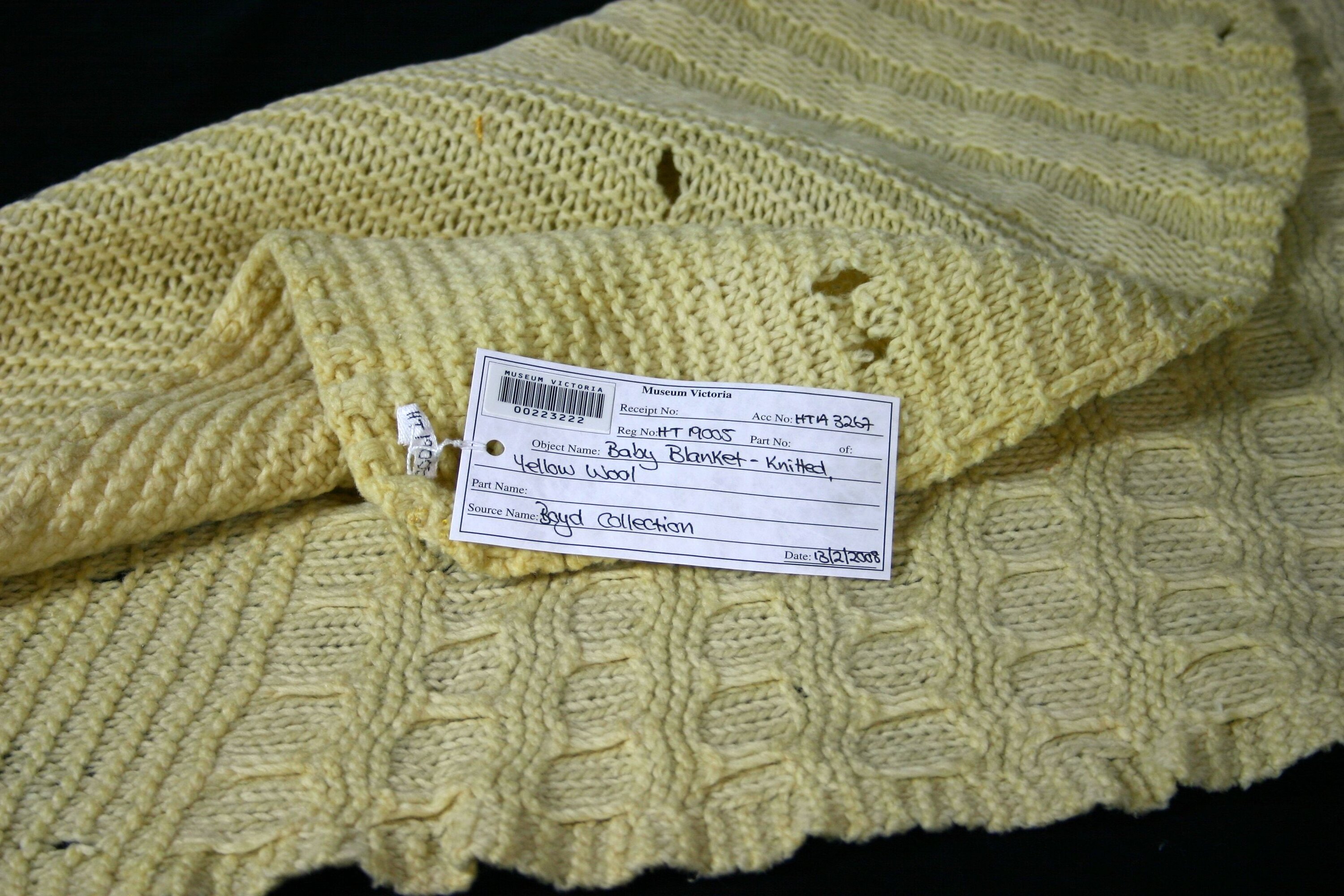 A folded handmade baby blanket on a chair