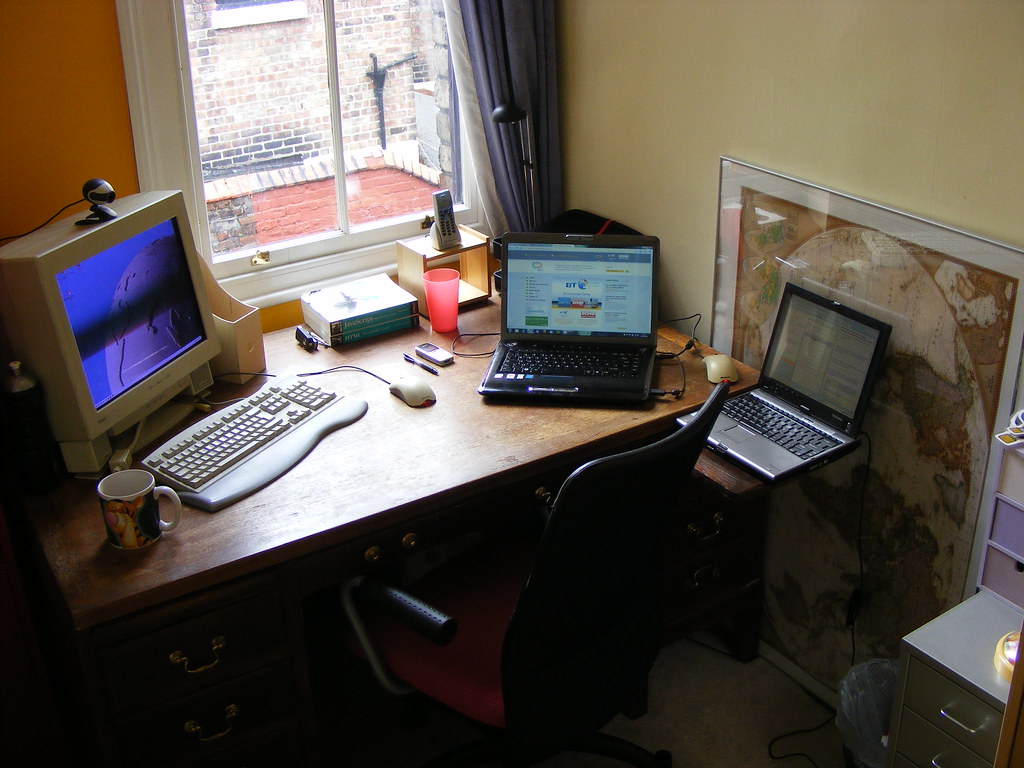 An office desk with a laptop and notebook