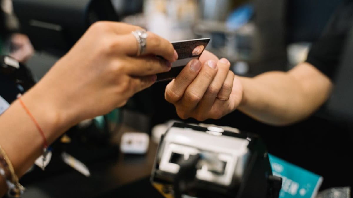 A payment card being handed across a counter