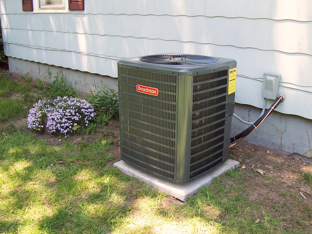 An outdoor condenser unit beside a house