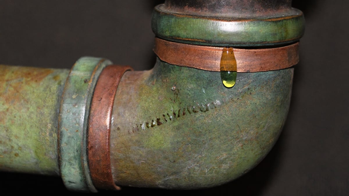 A copper pipe joint under a sink