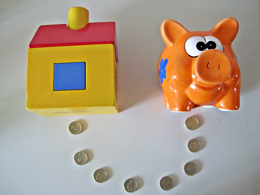 A model house beside coins