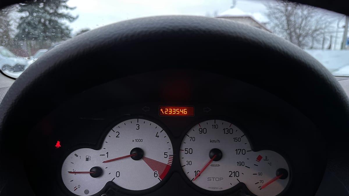 A car dashboard and steering wheel in daylight