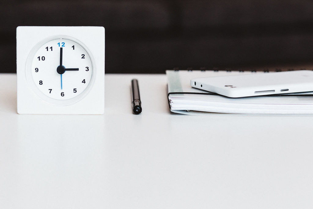 A clock and a calendar on a desk